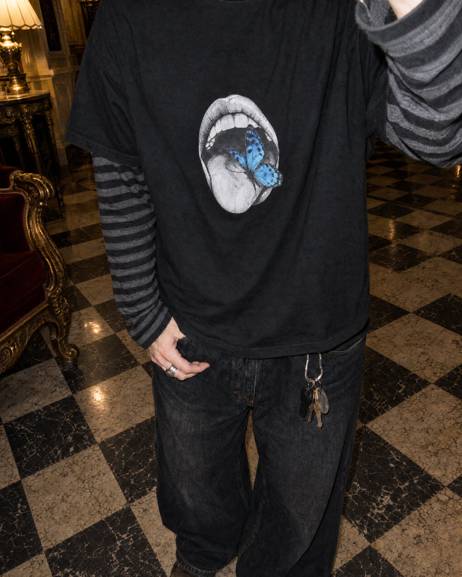 Blue butterfly mouth T-shirt on a checkered marble floor